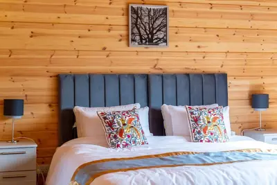 a bedroom with a large bed with pillows at Meadow Valley Lodge 1 in Ipswich