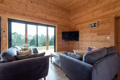 a living room with two couches and a television at Meadow Valley Lodge 1 in Ipswich