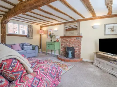 a living room with a couch and a fireplace at 3 The Almshouse in Saxmundham