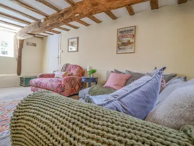 a living room with a couch and two chairs at 3 The Almshouse in Saxmundham