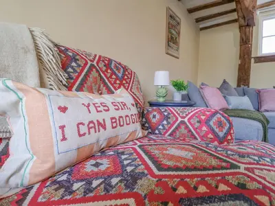 a bedroom with a bed with pillows and a couch at 3 The Almshouse in Saxmundham
