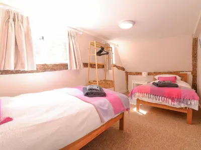 a bedroom with two beds and a window at 3 The Almshouse in Saxmundham