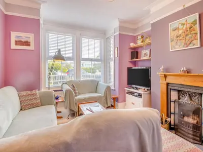 a living room with purple walls and a fireplace at Beachcombers Retreat in Felixstowe