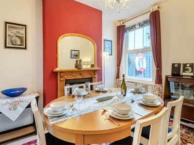 a dining room with a wooden table and a mirror at Beachcombers Retreat in Felixstowe