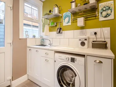 a kitchen with a washing machine and a sink at Beachcombers Retreat in Felixstowe
