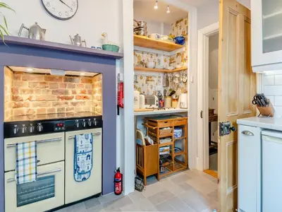 a kitchen with a stove and a wall at Beachcombers Retreat in Felixstowe