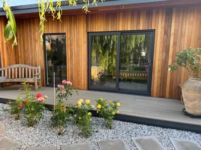 a porch of a house with flowers and a bench at Gorgeous studio! in Cherry Hinton