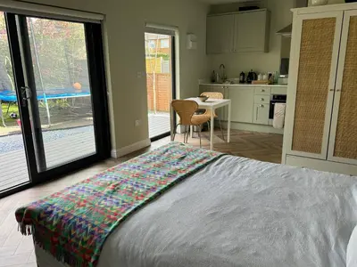a bedroom with a bed and a kitchen with a table at Gorgeous studio! in Cherry Hinton