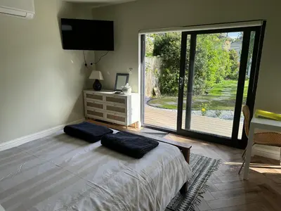 a bedroom with a bed and a large sliding glass door at Gorgeous studio! in Cherry Hinton