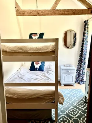 a bunk bed in a room with a bunk bed in a room at Oak Grange holiday cottage in Hoxne