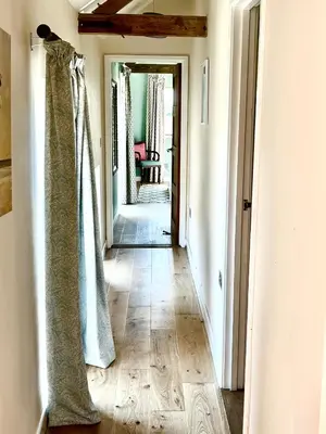 a hallway with a door leading into a room at Oak Grange holiday cottage in Hoxne