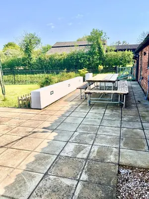 a patio with a table and benches on it at Oak Grange holiday cottage in Hoxne