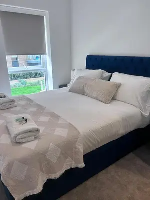 a bed with towels on it in a bedroom at The Ivy Abode 2 bedroom Apartment in Harlow