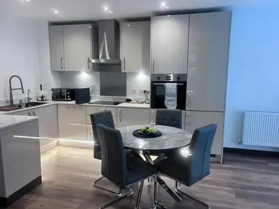 a kitchen with a table and chairs in a room at The Ivy Abode 2 bedroom Apartment in Harlow