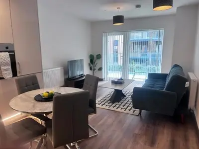 a living room with a table and a couch at The Ivy Abode 2 bedroom Apartment in Harlow
