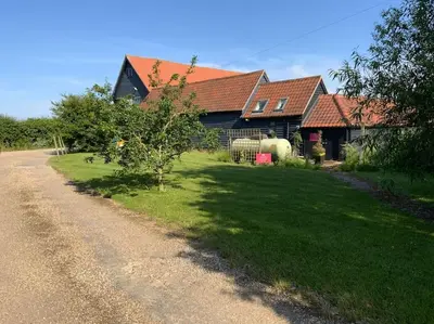 a house with a grass yard next to a road at Mersea best kept secret in Colchester