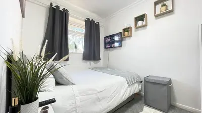 a small bedroom with a bed and a window at Lovely 3 bedroom house near city centre - Basildon in Basildon