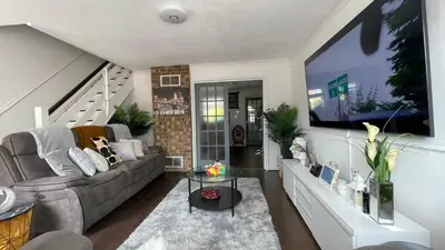 a living room with a couch and a tv at Lovely 3 bedroom house near city centre - Basildon in Basildon