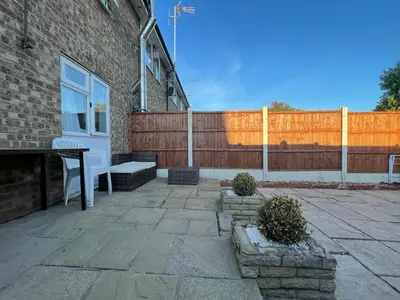 a patio with a white door and a fence at Lovely 3 bedroom house near city centre - Basildon in Basildon