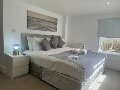 a bedroom with a large bed and a window at Relaxing 1 bedroom garden flat. in Brentwood