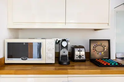 a microwave and other appliances sitting on a counter at En-suite with double bed on mezzanine and desk in family home in Hertford