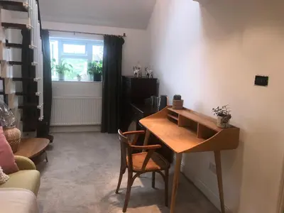 a living room with a wooden table and chairs at En-suite with double bed on mezzanine and desk in family home in Hertford