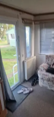 a living room with a couch and a window at Rose Manor in Little Clacton