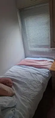 a bed in a room with a window with a bed sqor at Rose Manor in Little Clacton