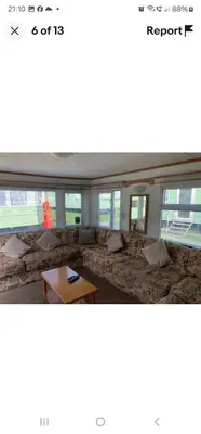 a living room with a large couch and a table at Rose Manor in Little Clacton