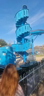 a woman standing in front of a blue machine at Rose Manor in Little Clacton