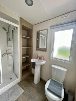 a bathroom with a toilet and a sink and a shower at Caravan at Seawick Holiday Park Close to Beach in Saint Osyth