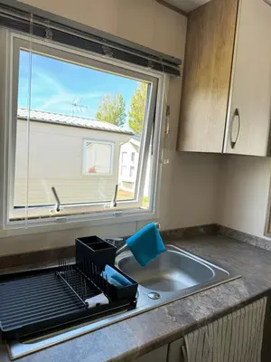 a kitchen counter with a sink and a window at Caravan at Seawick Holiday Park Close to Beach in Saint Osyth