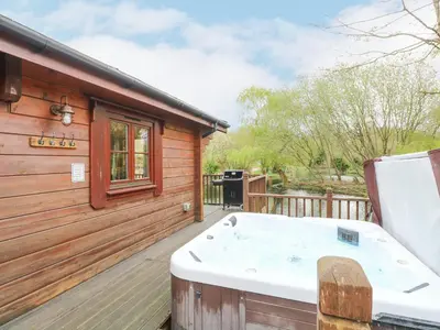 a hot tub on the deck of a cabin at Kingfisher Lodge in Langham