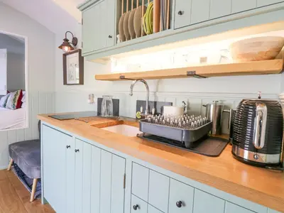 a kitchen with a sink and a counter top with aounter at Damsel Shepherds Hut in Badwell Ash