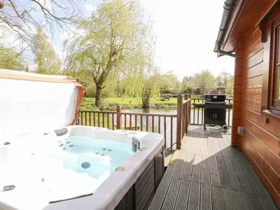 a jacuzzi tub on a deck with a grill at Heron Lodge in Langham