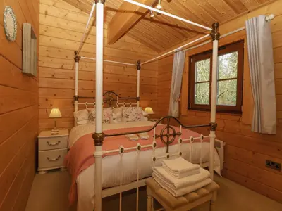 a bedroom with a bed in a log cabin at Heron Lodge in Langham