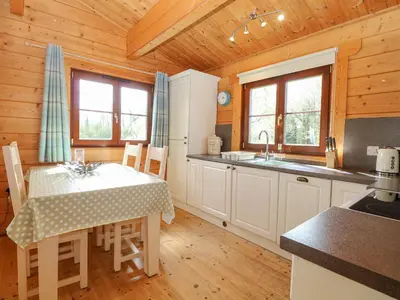 a kitchen with a table and chairs in a cabin at Heron Lodge in Langham