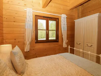 a bedroom with a bed in a log cabin at Wagtail Lodge in Langham