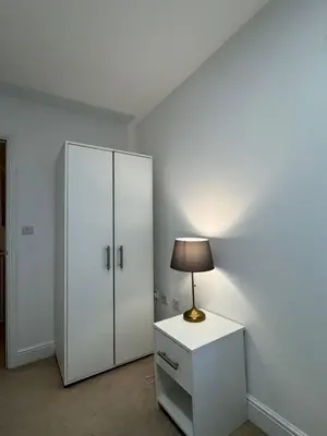 a room with a white cabinet and a lamp at St Nicolas Cottage in Ipswich