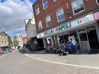 a group of people sitting in chairs outside of a store at St Nicolas Cottage in Ipswich