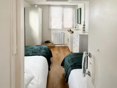 a bedroom with two beds and a sink in it at Angie's Beachside House in Brightlingsea