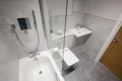 a white bathroom with a shower and a sink at Modern,Bright and spacious 2 bed in Brentwood