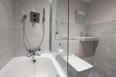 a bathroom with a shower and a tub and a sink at Modern,Bright and spacious 2 bed in Brentwood