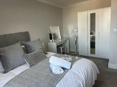 a bedroom with a bed with two towels on it at Bright, spacious 1 bedroom flat in Brentwood