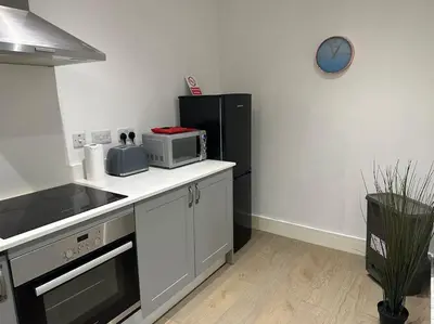 a kitchen with a microwave and a refrigerator at Bright, spacious and modern flat in Brentwood