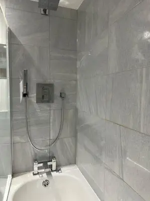 a bathroom with a shower and a bath tub at Bright, spacious and modern flat in Brentwood