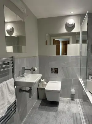 a bathroom with a toilet and a sink at Bright, spacious and modern flat in Brentwood