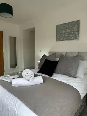 a bedroom with a bed with towels on it at Bright, spacious and modern flat in Brentwood