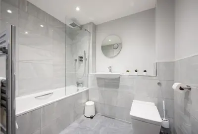 a white bathroom with a shower and a toilet at Cosy, Bright and Spacious Flat in Brentwood