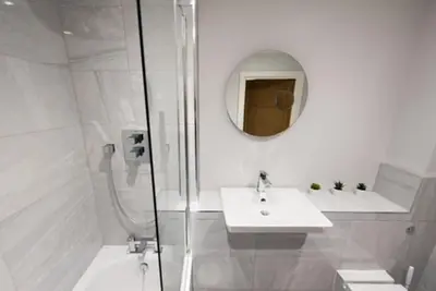 a white bathroom with a sink and a shower at Cosy, Bright and Spacious Flat in Brentwood